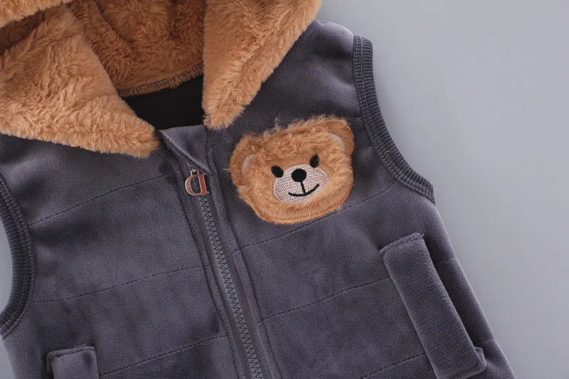 Upper section of grey zippered vest with faux fur collar, embroidered bear patch, and metal D-shaped pull