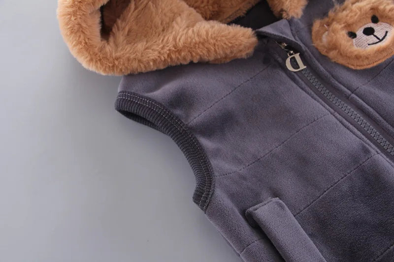 Side view of grey vest highlighting ribbed armhole binding, quilted fabric texture, and brown fur lining edge