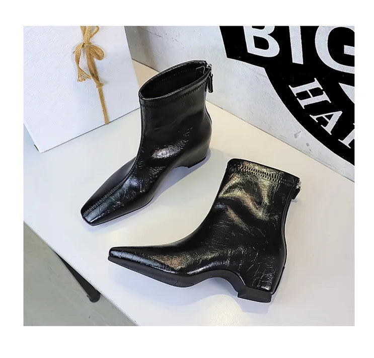 Botas pretas metálicas enrugadas com bico quadrado e salto bloco baixo em exposição