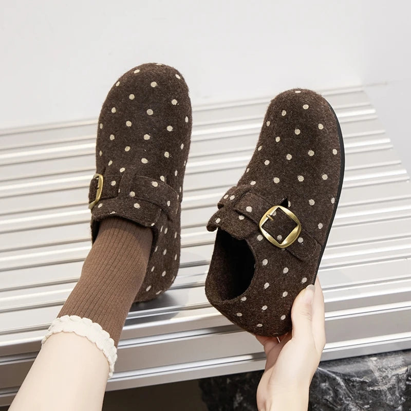 Zapatos de fieltro marrones con lunares usados con calcetines acanalados sobre superficie plateada