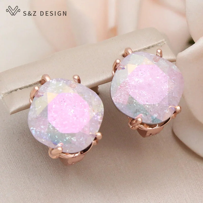 Brincos pendentes em ouro rosa mostrando tons iridescentes rosa e branco em cristais texturizados contra flores claras