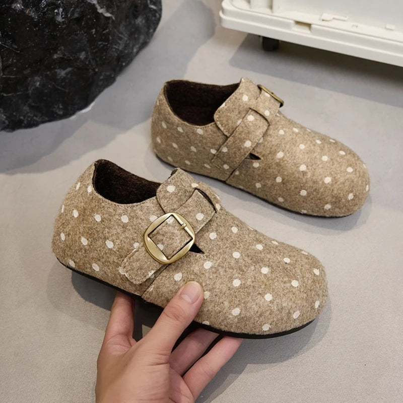 Mano mostrando forro felpado marrón oscuro y textura suave de zapatillas beige con lunares