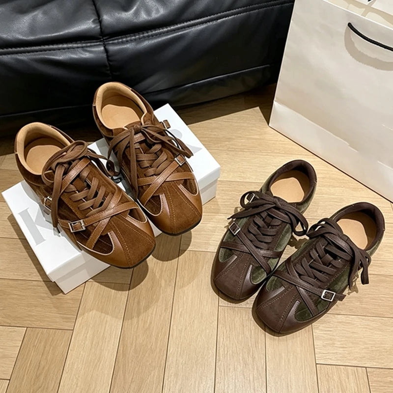 Tan and olive green retro sneakers with silver buckles on a wooden floor near a black sofa