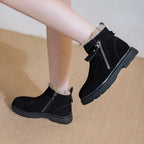 Perfil lateral de piernas de modelo en botas de invierno de ante negro con suela de plataforma y cremallera plateada al dar un paso