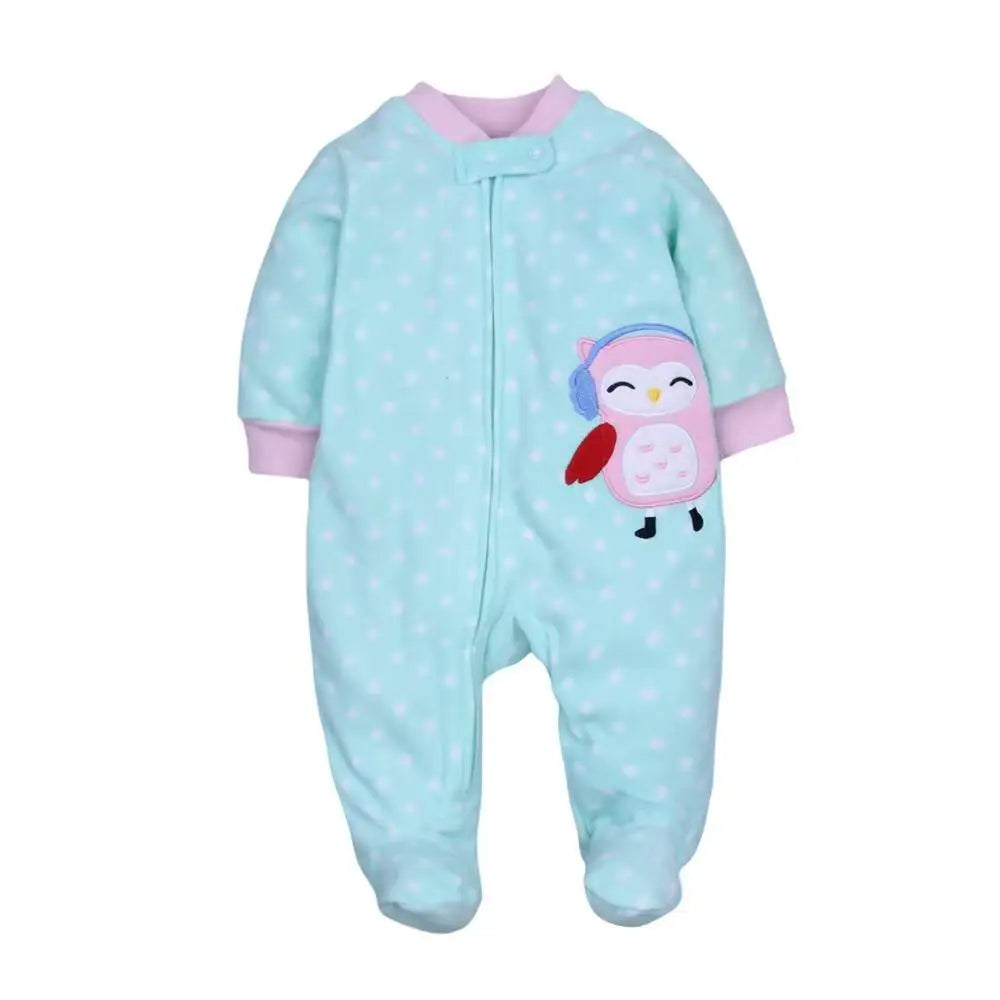 Mint green polka dot onesie with pink trim and embroidered owl applique wearing blue earmuffs on chest