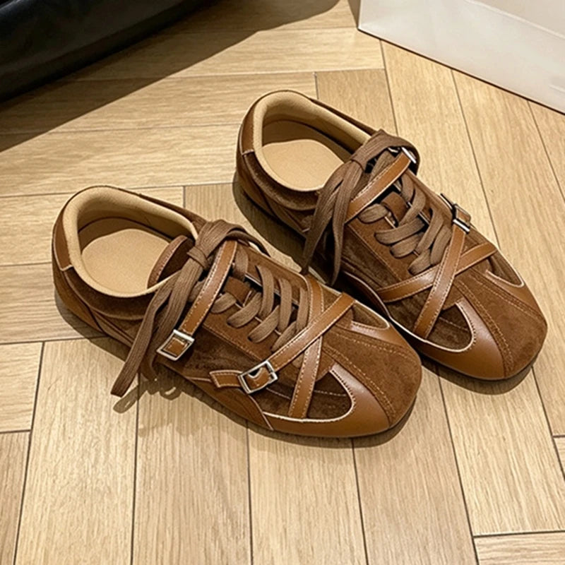 Warm brown lace-up training shoes highlighting textured suede upper and metallic buckle accents