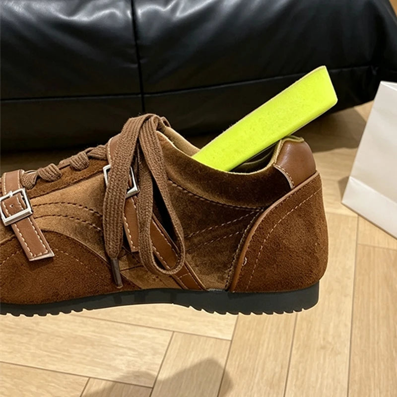 Macro shot of brown sneaker side with lime green shoe tree emphasizing suede texture and buckle
