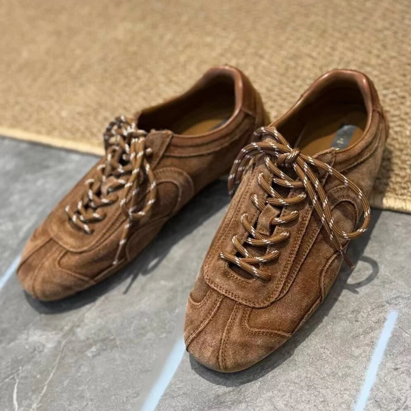 Brown genuine leather sneakers on marble floor with patterned rope laces