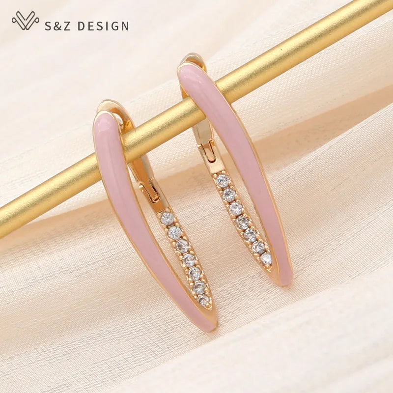 Close-up de brincos argola em ouro rosa com esmalte rosa pastel e detalhes cintilantes de zircônia cúbica
