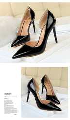Glänzende schwarze pointed-toe Pumps mit Seitenausschnitt auf weißer Box mit Zeitschrift als Deko, reflektierendes Material im Fokus