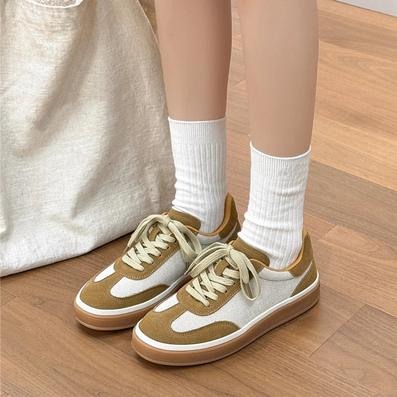 Front-facing olive green and white casual sneakers with mesh upper, beige laces, and tan outsole