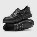 Seitenansicht schwarzer Stiefel mit Nieten, dicke Gummisohle, verstellbare Schnallen und Metall-O-Ring nahe der Ferse