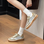 Dynamic side angle of sneaker silhouette with smooth gum sole as model lifts foot for walking fit