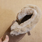 Primer plano del cuello de bota marrón de ante con forro de felpa beige doblado y cremallera lateral sobre fondo texturizado