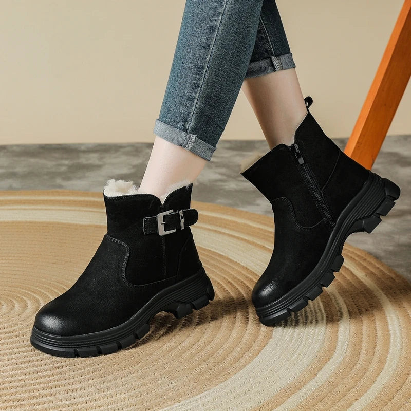Γυναίκα να φοράει μαύρα αληθινά δερμάτινα ankle boots με χοντρό πάτο, ασημί πόρπη και λευκή επένδυση