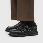 Frontalansicht Paar schwarzer Loafer: symmetrische Gurte, glatte Ledertextur und dicke Gummi-Außensohle