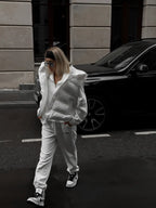 Foto corporal ao ar livre de modelo a caminhar com colete acolchoado branco em rua molhada