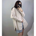 Vista laterale di camicia bottoni beige indossata aperta sopra shorts denim mostrando caduta e versatilità