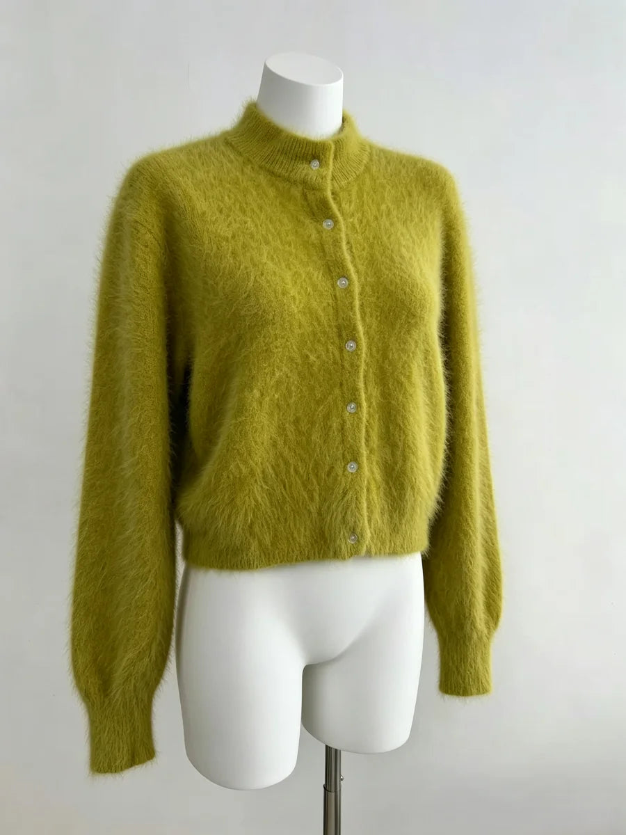 Cardigan longo de pelúcia verde oliva em manequim branco com material felpudo macio, punhos canelados e botões verticais