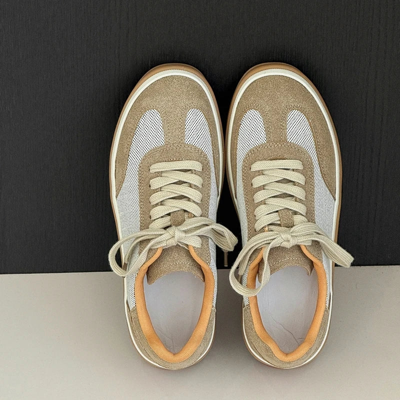 Overhead shot of beige sneakers on split background, emphasizing rounded toe, stitching, and orange lining
