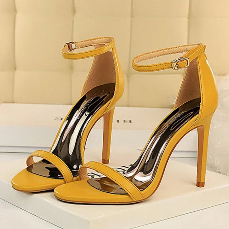 Saltos stiletto amarelo mostarda vibrantes com parte superior brilhante, bico aberto e delicada alça de tornozelo fina