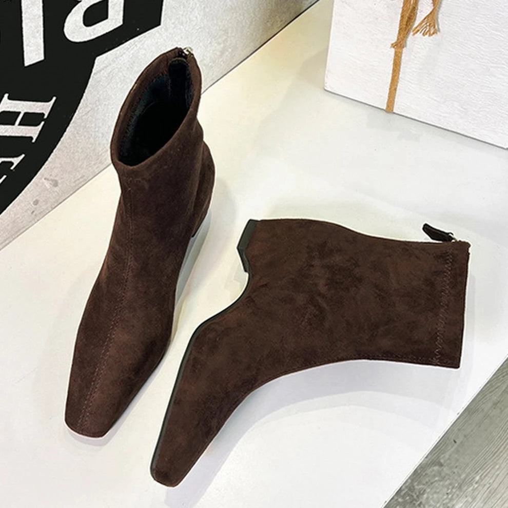 Dunkelbraune Wildlederschnürsenkel-Stiefel mit quadratischer Spitze und niedrigem Blockabsatz auf weißer Oberfläche.
