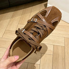 Close-up of brown sneaker showing contrast between matte suede and glossy leather sections