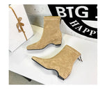 Seitenprofil beige Wildlederschuhe auf glänzendem Tisch: schlanke Silhouette, keilförmiger Absatz und nahtloses Obermaterial.