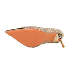 Orangefarbene Gummisohle mit Rastergriffmuster unter glitzerndem schwarzem Schuhoberteil