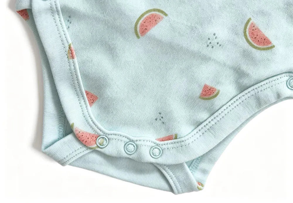 Detail shot of light blue cotton bodysuit with watermelon print, neat hem stitching, and three crotch snaps