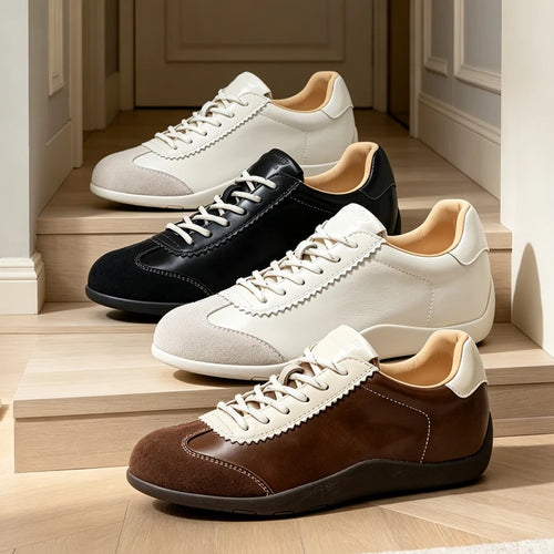 Cuatro zapatillas lace-up patchwork en crema, negro y marrón dispuestas en diagonal sobre escalones de madera