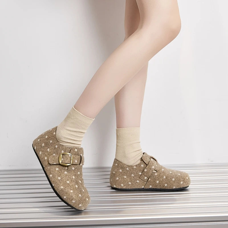 Plano completo de modelo usando zapatos beige con lunares y calcetines crema sobre superficie