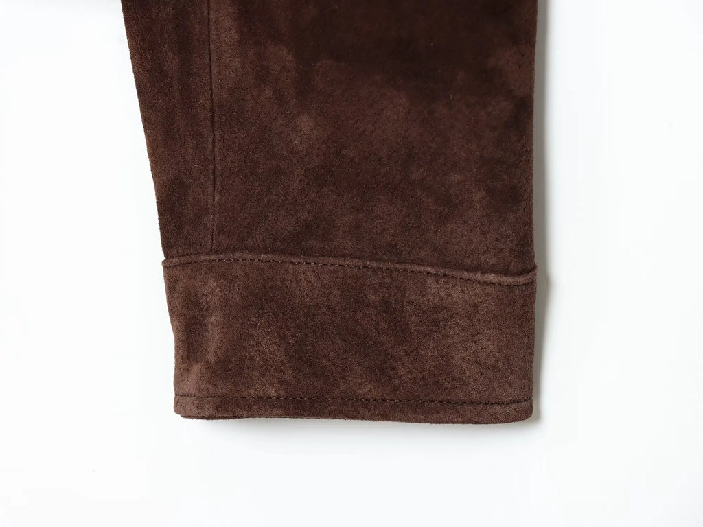 Punho da manga da jaqueta suede castanha-escura com barra estruturada larga, costura precisa e textura macia.