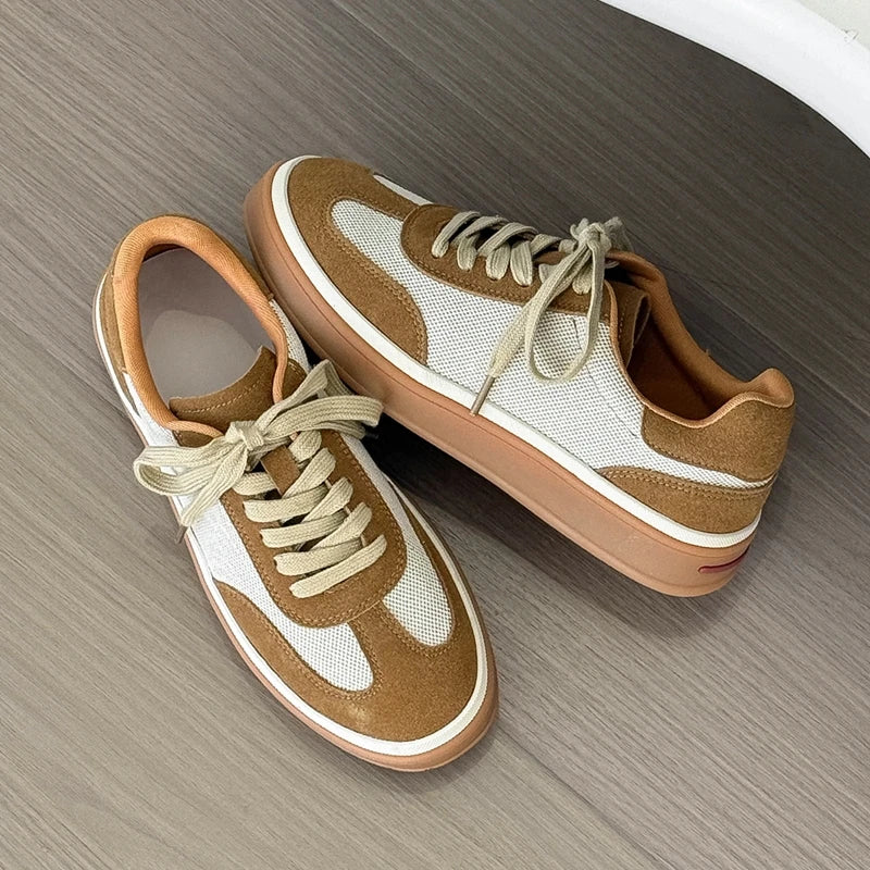 Top-down view of sneakers on grey floor, highlighting white mesh toe, brown suede sides, and tan outsole