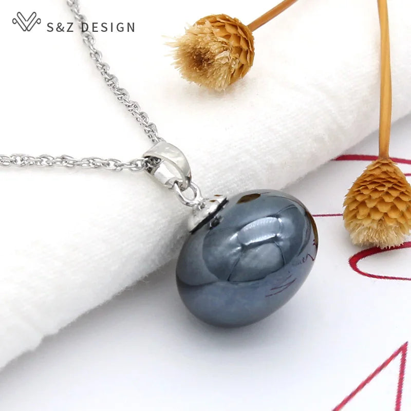 Pingente oval de pérola simulada cinza escuro na necklace em elo prateado com caules de flor