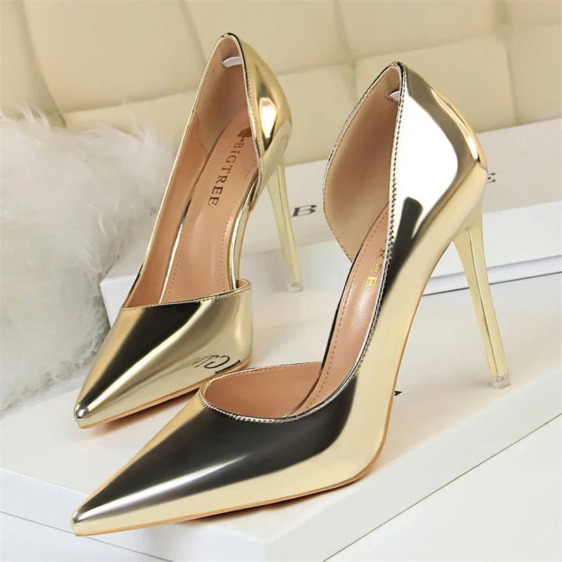 Glänzende metallische Gold-pointed-toe Pumps auf weißer Plattform mit weißem Fell-Akzent, spiegelglatter Finish und elegante Silhouette