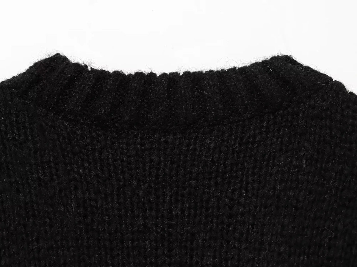 Vista macro do decote crewneck canelado preto realçando a textura macia e felpuda da malha e detalhes de costura