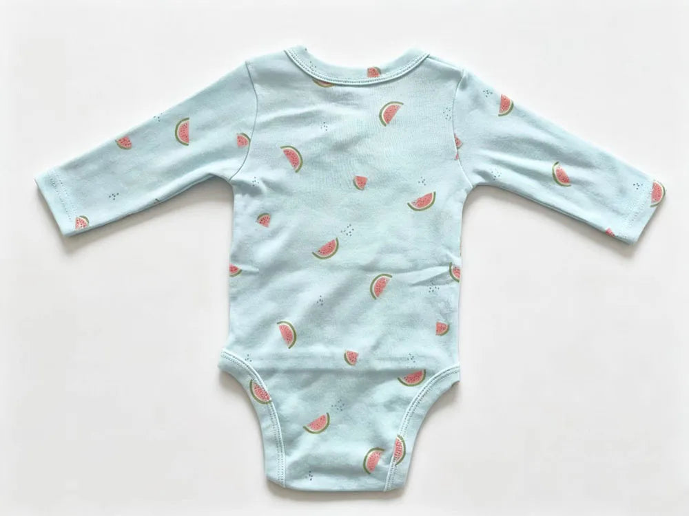 Flat-lay of infant jumpsuit on white background highlighting soft knit texture and scattered watermelon graphics