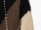 Close-up do design diagonal em blocos de cor em preto, castanho chocolate e bege com costuras verticais em V brancas