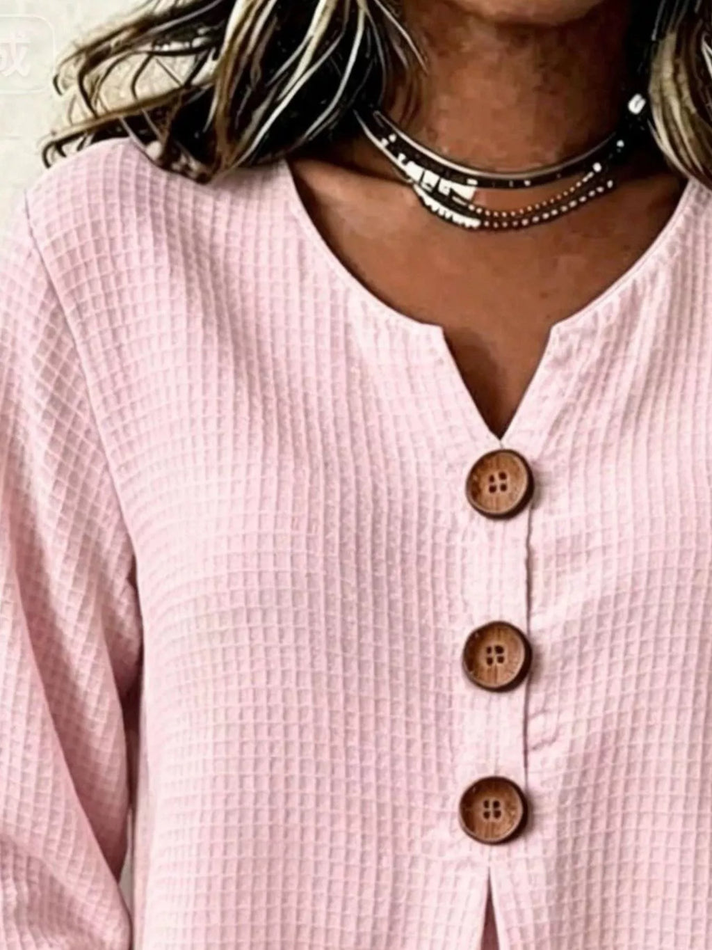 Blusa de tela texturizada en rejilla rosa con cuello abierto en V y collar