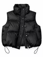 Front view of black insulated vest showing zipper, snaps, and high collar