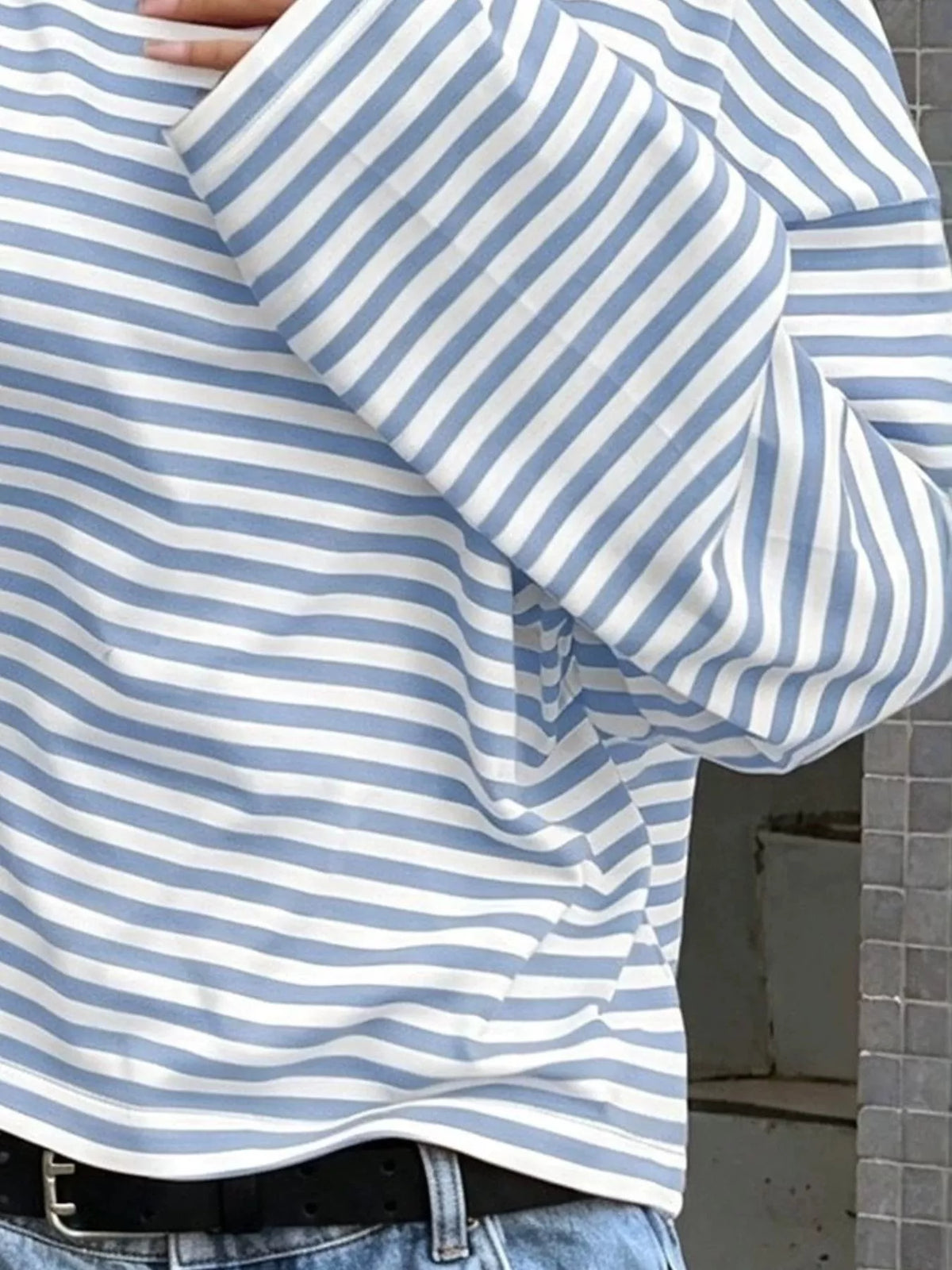 Macro shot of blue and white striped fabric weave showing flexibility as arm is raised to emphasize comfortable stretch