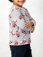 Side view of child in grey cotton shirt showing sleeve length and continuous red rescue vehicle pattern