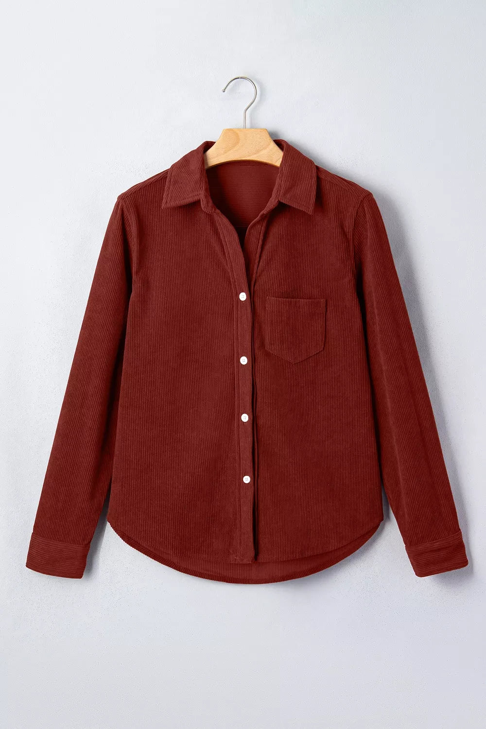 Rust-brown corduroy long sleeve shirt on hanger showing pointed collar and white buttons