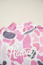 Close-up of ribbed mock neck and white glittery Howdy lettering on soft polyester fabric