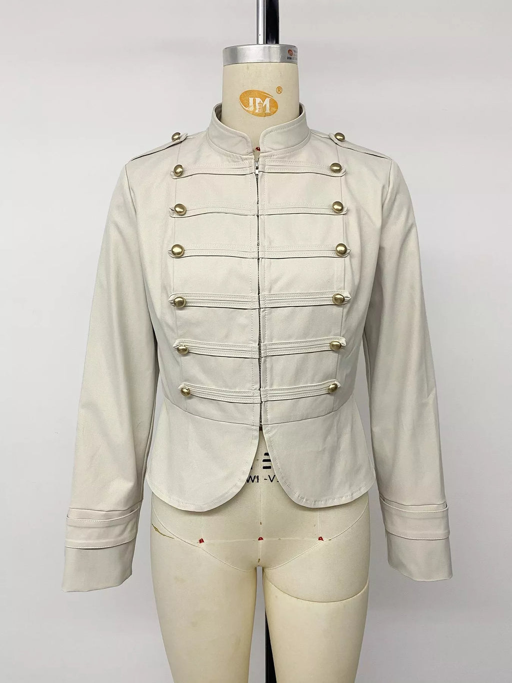 Vue avant d'une veste crème entièrement zippée montrant le col relevé et la devanture à boutons symétrique