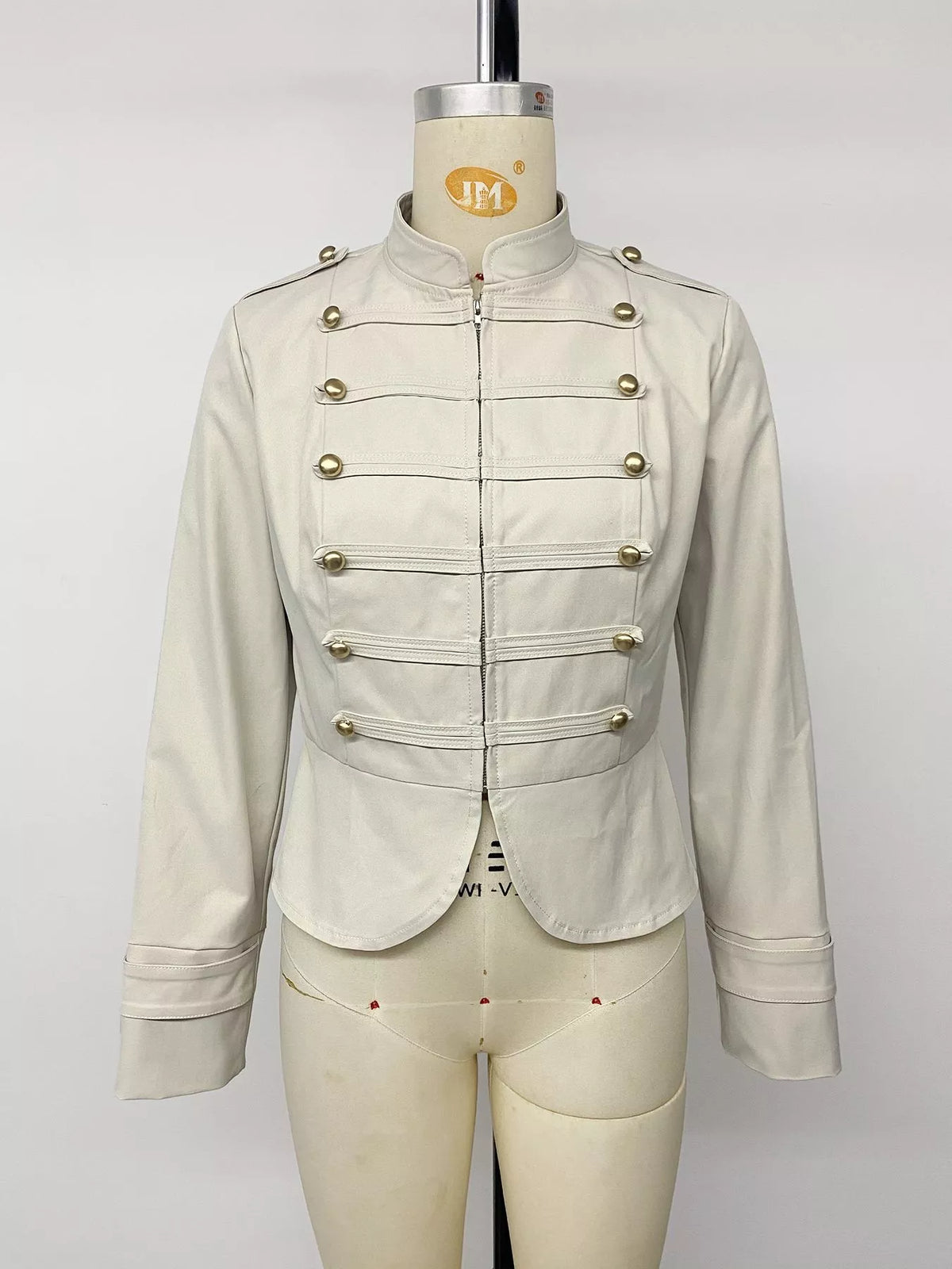 Vue avant d'une veste crème entièrement zippée montrant le col relevé et la devanture à boutons symétrique