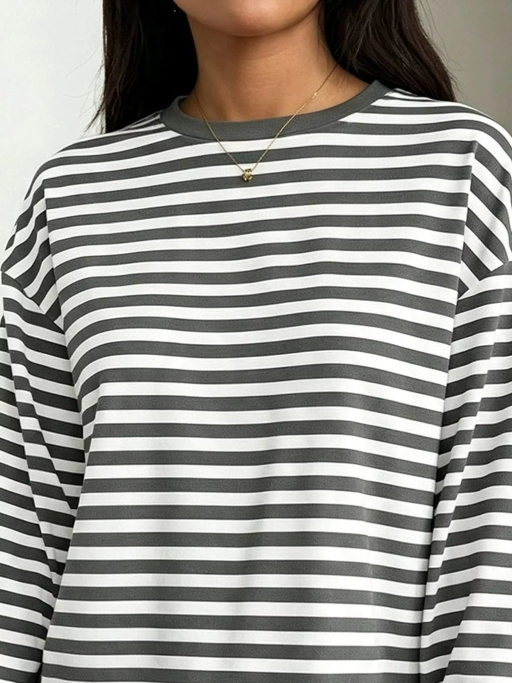 Grey and white striped t-shirt detail featuring ribbed collar, dropped shoulder seam, and soft stretchy fabric texture