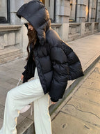 Side view of model in black puffer jacket with large hood revealing soft white fur lining inside