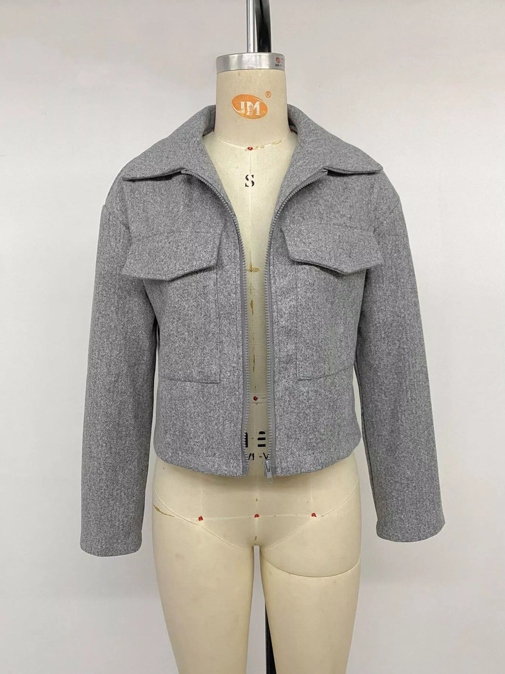 Graue Perfee Zip-Up Cropped Shacket am Mannequin mit geöffnetem silbernen Reißverschluss, der breite spitze Kragenenden und große Brusttaschen enthüllt